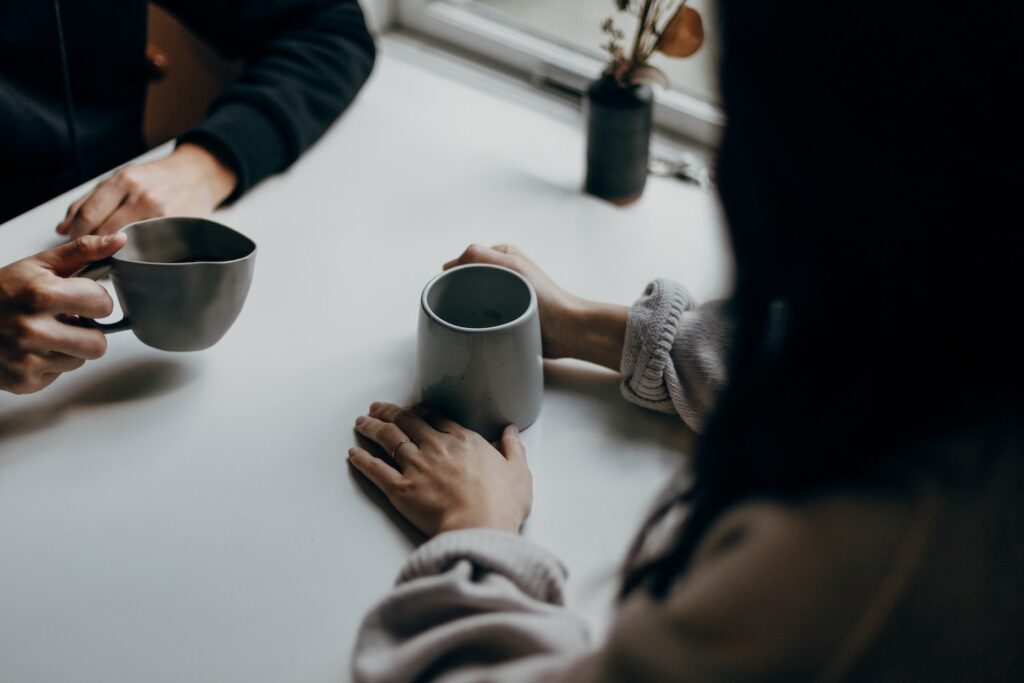 Two people in a coaching session having coffee